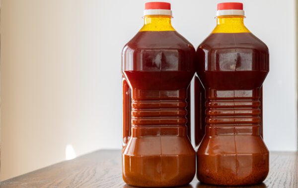 Two bottles of ketchup sitting on a table.