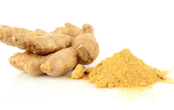 A pile of ginger next to a pile of ground turmeric.