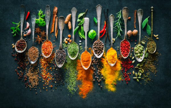 A table topped with lots of spoons filled with different types of food.