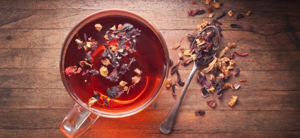 A cup of tea with some dried fruit on the side.